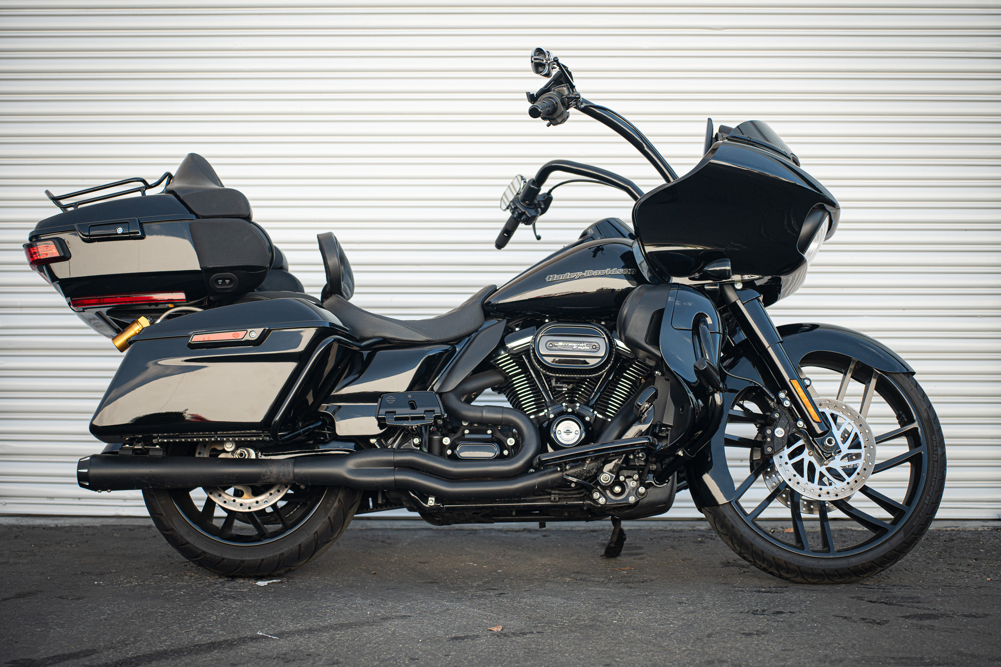 Harley Davidson sits on its kickstand in front of an industrial garage